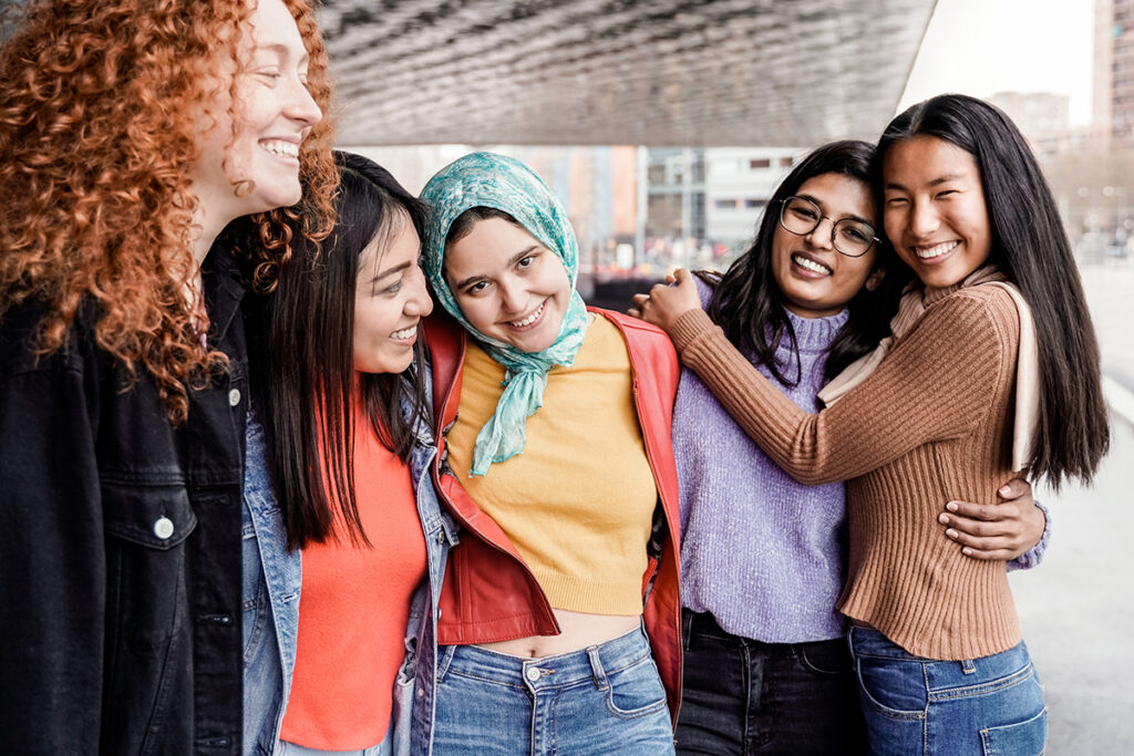 Multiethnic female friends having fun outdoor People from diverse cultures and races Focus on Muslim girl face